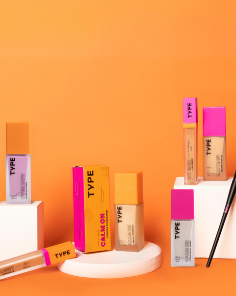 "ACE YOUR BASE BUNDLE featuring colorful makeup products on orange background."