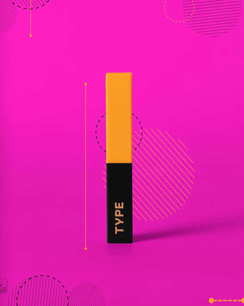 Light Up Lipstick with vibrant yellow and black packaging against pink background.